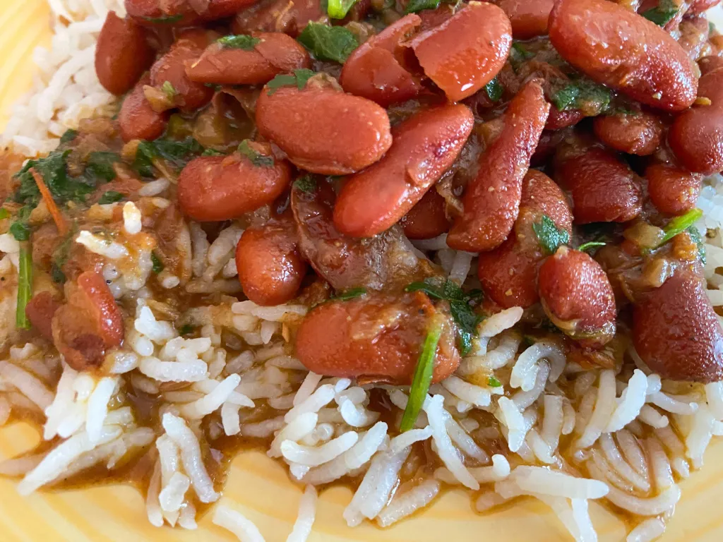 A traditional Indian meal featuring Rajma Masala served with rice, garnished with fresh coriander leaves.